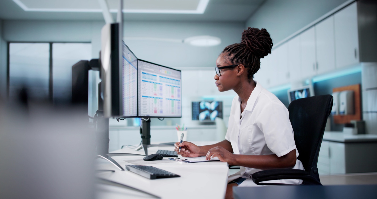 Medical billing specialist entering claims on a laptop beside a stethoscope